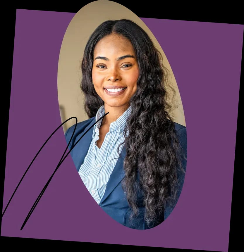 A woman with long, wavy hair smiles warmly at the camera. She is wearing a blue blazer over a pinstriped shirt. The background, reminiscent of media editing effects, features a purple oval with a black scribble near the left edge.